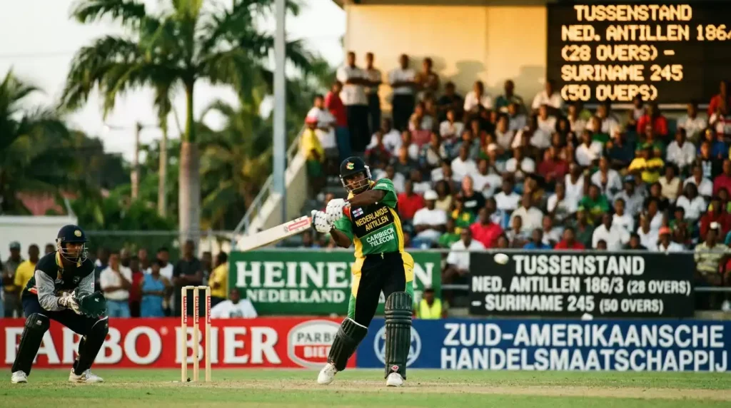 Caribische cricketspeler slaat de bal richting boundary tijdens avondwedstrijd onder lichten