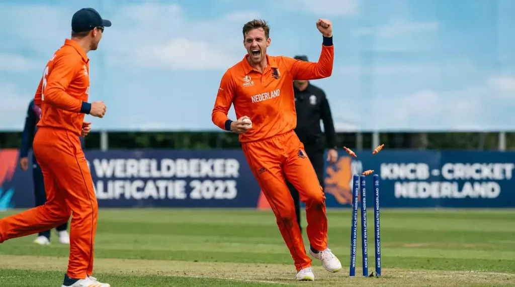 Nederlandse cricketspeler in oranje shirt celebreert wicket tijdens internationale wedstrijd